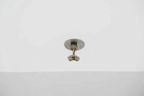 Fire sprinkle head mounted on a clean white ceiling Stock Photos