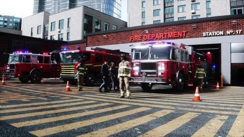 Fire station. A firefighter stands next to a fire engine. Video stock 333418670