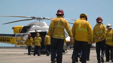 Fire team walking towards helicopter in airfield Stock Footage 116470842