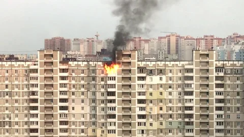 Fire on the top floor of a multi-storey building. Flames burst from the windows. Stock Footage 116614545