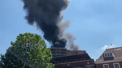 A fire at the top of a newly built tower block in Staines, UK Stock Footage 278179553