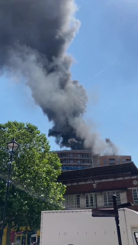 A fire at the top of a newly built tower block in Staines, UK Stock Footage 278179560