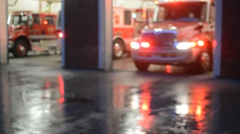 Fire Truck  and Ambulance Pull Out Of Station At Dusk On Rainy Day Stock Footage
