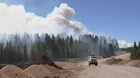 Fire Truck driving towards camera with smoke &amp; trees in background Stock Footage 40752745