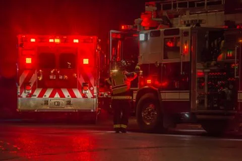Fire truck, firefighter, ambulance responding to car crash at night Stock Photos