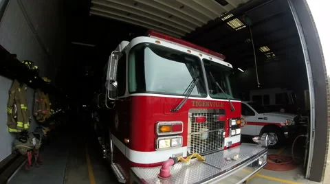 Fire truck pulling out of station with emergency lights on Stock Footage