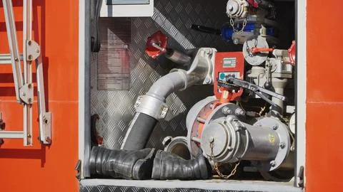 Fire truck pump system with red hoses and emergency equipment for rescue Stock Photos