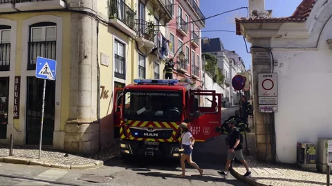 Fire Truck Wit Firefighters Responding on Narrow Urban Street In Lisbon Stock Footage 329561709