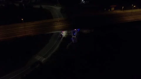 Fire trucks fire hose preparing to extinguish a fire at night under the bridge Stock Footage 157998324