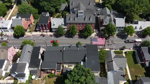 Fire trucks lead parade past brick townhomes lined with crowds in Lititz Stock Footage 340139609