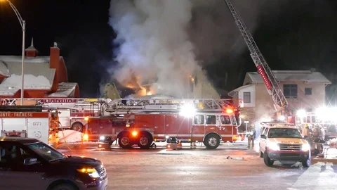 Fire viewed by walking news crews at night with flames showing Stock Footage 85397296