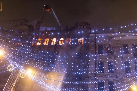 Fire in the windows of the old building at night in winter against the backgr Stock Photos