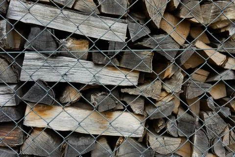 Fire wood stack piled up behind fence Stock Photos