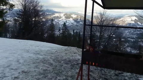 Fire of wooden logs in brazier in snow on top of a snowy mountain. Stock Footage 100162709