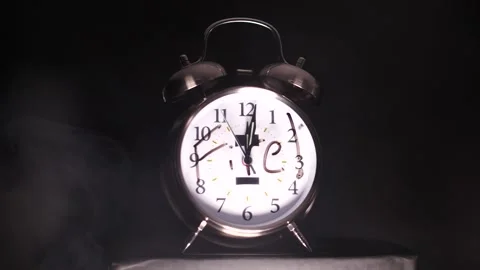 Fire written on silver dual bell alarm clock with smoke rising in slow motion Stock Footage 206583317