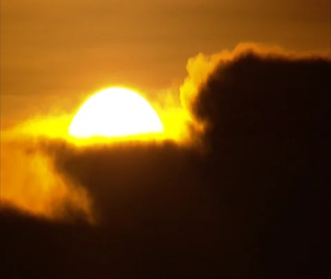 Fireball sun rising in dark clouds in orange sky Stock Footage 86747726