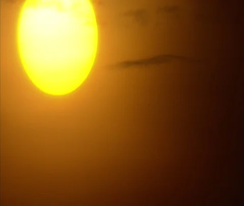 Fireball sun setting in orange clouds Stock Footage 86747387