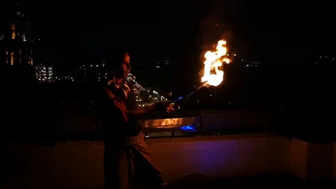 Firebreather performing a fireshow on a rooftop in Mexico Stock Footage 129259178