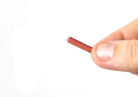 Firecracker with a wick in hand on a white background, isolate, close-up. Copy Foto stock