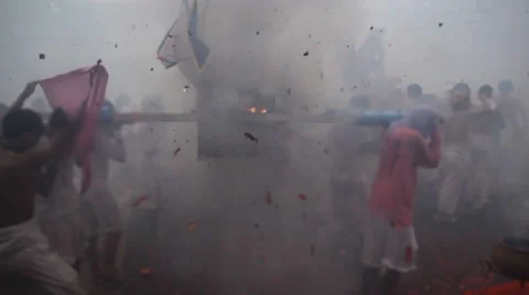 Firecrackers explode over Chinese street procession during festival Stock Footage 60182943