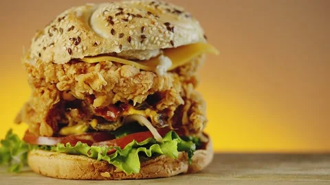 Fired crispy chicken burger with cheddar cheese, lettuce, tomato and onion Stock Footage 162615848