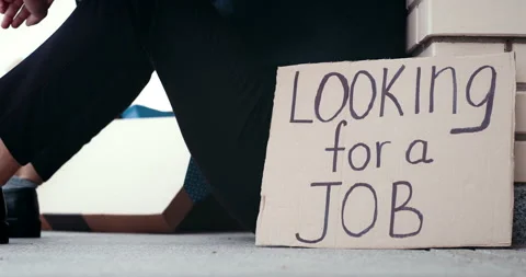 Fired depressed man sitting on ground next to carton banner saying looking for a 스톡 동영상 138703451