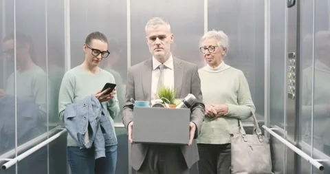 Fired man carrying a box with his belongings in the elevator Stock Footage 306149763