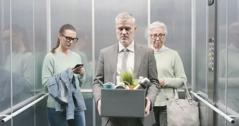 Fired man carrying a box with his belongings in the elevator 库存影片 306149772