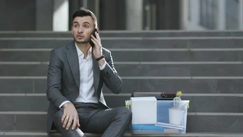 Fired man talking on phone with stuff in box. Cellphone conversation. Speaking Stock Footage 194518967