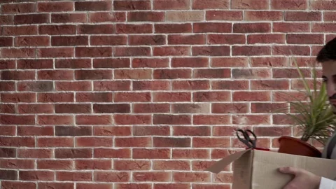 Fired, sad guy, Eastern appearance, enters the frame with a brick wall, shrugs Stock Footage 121802394