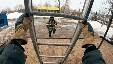 Firefighte .  Ascend the pull-out ladder to the third floor window. Stock Footage 121363758