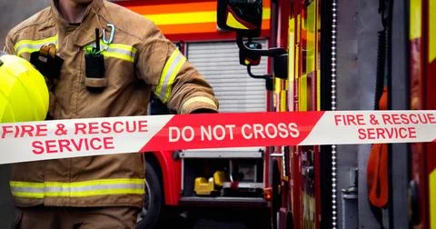 Firefighter in action at fire scene - hand of fireman reaching for fire engine 스톡 사진