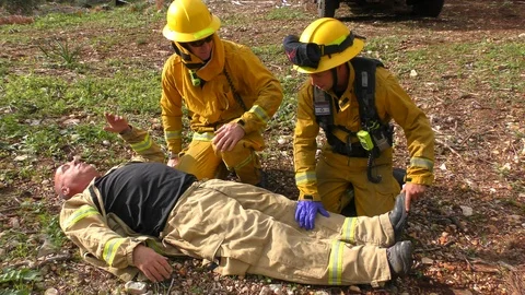 Firefighter and paramedic provide first aid to an injured firefighter 스톡 동영상 99810444