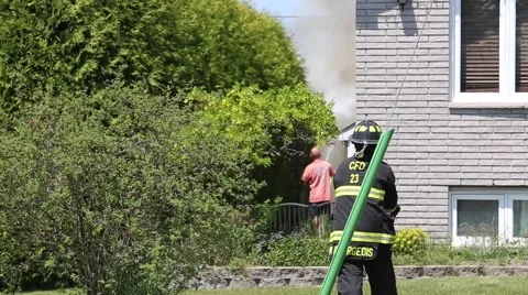 Firefighter approaches fire in background Stock Footage 64222516