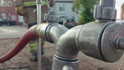 Firefighter approaching fire hose connection after emergency response Stock Footage 344104149