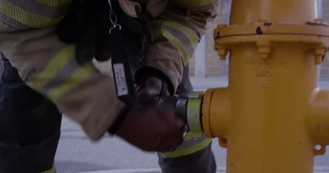 Firefighter attaching a fire hose to a fire hydrant Stock Footage 107627923