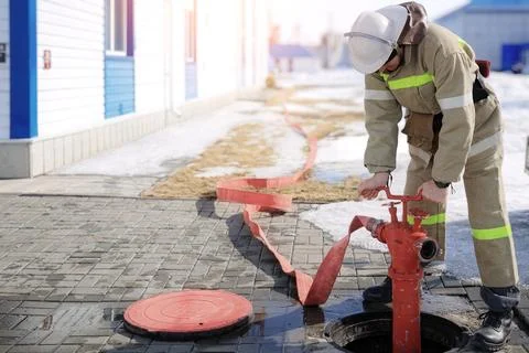 Firefighter attaching hose to hydrant Foto stock
