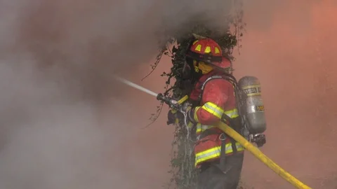 Firefighter attacking large blaze in thick smoke Vídeos de archivo 91015982