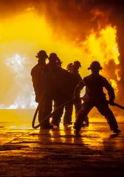 Firefighter bracing during firefighting Stock Photos