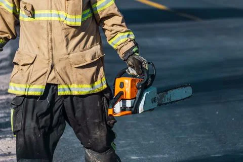Firefighter with chainsaw in rescue. Stock Photos
