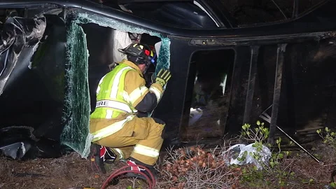 Firefighter checking patient of rollover car accident Stock Footage 219300458