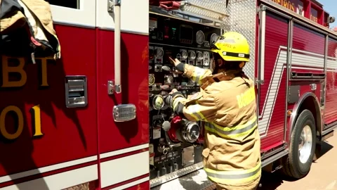 Firefighter checks the firetruck equipment panel while responding to a Stock Footage 138472648