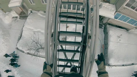 A firefighter climbs the fire ladder into the window of the 4th floor. Stock Footage 158595656