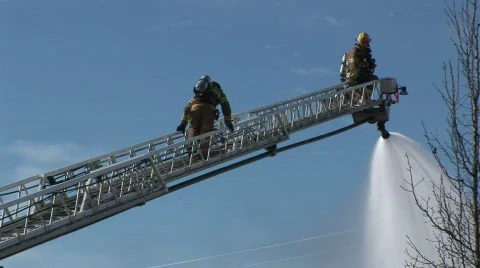 Firefighter climbs ladder Stock Footage