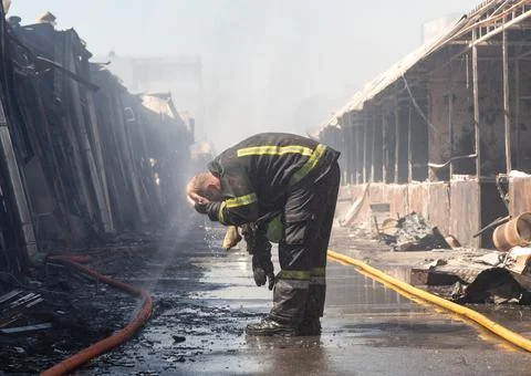 Firefighter cooling off during Pochaina market blaze Stock Photos