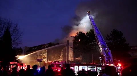 Firefighter crews battling apartment complex fire at night Stock Footage 47344312