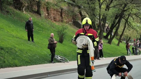 Firefighter deploys fire hose while extinguishing a fire Stock Footage 239374701