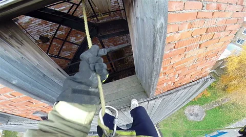 Firefighter descend on a rope from a window of the 5th floor. Stock Footage 53290436