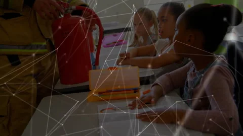 Firefighter entering classroom and demonstrating red extinguisher use for Stockbeeldmateriaal 311505465