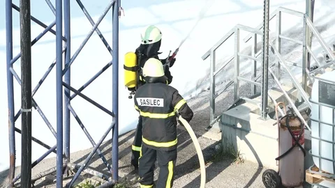 Firefighter extinguishing fire Stockbeeldmateriaal 100328777